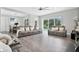 Open living space with gray couches, hardwood floors, and sliding doors leading to pool at 1317 Spring Lake Ter, Ocoee, FL 34761