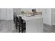 Modern kitchen island with white quartz countertop and seating for three at 1317 Spring Lake Ter, Ocoee, FL 34761