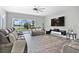 Living area with grey sectional, large screen TV and access to backyard pool at 1317 Spring Lake Ter, Ocoee, FL 34761