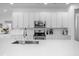 Modern kitchen with white cabinets, stainless steel appliances, and quartz countertops at 3951 Oakville Ave, Kissimmee, FL 34741