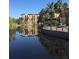Community with lake view, reflecting building and lush landscaping at 12521 Floridays Resort Dr # 302F, Orlando, FL 32821