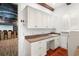 Laundry room with white cabinets, granite countertops, and a view of a home theatre at 7411 Gathering Ct, Reunion, FL 34747