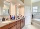 Double vanity bathroom with granite countertops and a large soaking tub at 16300 Johns Lake Rd, Clermont, FL 34711