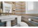 Stylish powder room with pedestal sink and unique striped wallpaper at 421 Lakewood Dr, Winter Park, FL 32789
