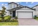 Two-story house with gray siding, two-car garage, and landscaping at 5953 Catamaran Ave, Haines City, FL 33844