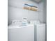 White washer and dryer set with overhead shelving at 4803 Brier Rose Ln, Kissimmee, FL 34746