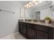 Double vanity bathroom with granite countertop and dark wood cabinets at 4803 Brier Rose Ln, Kissimmee, FL 34746