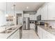 Modern kitchen featuring white cabinets, granite countertops, and stainless steel appliances at 8926 Zurich Ln, Kissimmee, FL 34747