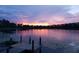 Serene lakefront property with a wooden dock at sunset at 16837 Arrowhead Blvd, Winter Garden, FL 34787
