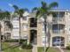 Exterior view of a two-story apartment building with palm trees at 2302 Silver Palm Dr # 301, Kissimmee, FL 34747