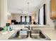 Kitchen with double sink, granite counters, and view into dining area at 702 Calabria Ave, Davenport, FL 33897