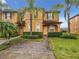 Two-story townhome with brick paver driveway and landscaping at 702 Calabria Ave, Davenport, FL 33897