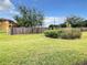 Landscaped yard with lush grass and a wooden fence, providing privacy at 702 Calabria Ave, Davenport, FL 33897