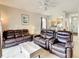 Comfortable living room boasts leather recliners and a view into the dining area at 702 Calabria Ave, Davenport, FL 33897