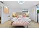 Primary bedroom with large bed, pink accents, and bench at 7487 Gathering Dr, Reunion, FL 34747