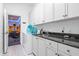 Laundry room with granite countertop and game room access at 7487 Gathering Dr, Reunion, FL 34747