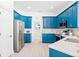 Spacious kitchen featuring teal cabinets and stainless steel appliances at 7487 Gathering Dr, Reunion, FL 34747