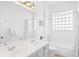 Clean bathroom with double vanity, bathtub, and glass block window at 7487 Gathering Dr, Reunion, FL 34747