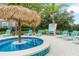 Pool area with tiki umbrella and lounge chairs at 7487 Gathering Dr, Reunion, FL 34747