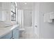 Simple bathroom with light blue vanity, bathtub, and marble floor at 7487 Gathering Dr, Reunion, FL 34747