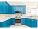 Modern kitchen with teal cabinets and stainless steel appliances at 7487 Gathering Dr, Reunion, FL 34747