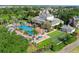 Aerial view of community pool with lounge chairs, bocce ball court, and clubhouse at 7487 Gathering Dr, Reunion, FL 34747