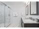Modern bathroom with double vanity and walk-in shower at 7487 Gathering Dr, Reunion, FL 34747