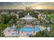 Community pool with lounge chairs and palm trees at 7487 Gathering Dr, Reunion, FL 34747