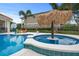 Inviting pool and spa with tiki bar and lounge chairs at 7487 Gathering Dr, Reunion, FL 34747
