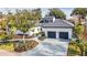 Stunning curb appeal featuring a modern white exterior, gray driveway, and manicured landscaping at 9217 Hidden Bay Ln, Orlando, FL 32819