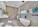 Bathroom with freestanding tub, marble, and chevron floors at 9217 Hidden Bay Ln, Orlando, FL 32819