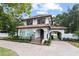 Front view of two-story home with terracotta tile roof and brick driveway at 1310 Aloma Ave, Winter Park, FL 32789