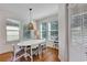 Bright dining room with white table and gray chairs, hardwood floors, and large windows at 9149 Outlook Rock Trl, Windermere, FL 34786