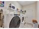 Bright laundry room with washer, dryer, and shelving at 9149 Outlook Rock Trl, Windermere, FL 34786