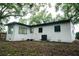 Newly renovated house exterior boasts a clean white finish, dark trim, and a landscaped yard at 635 Maitland Ave, Altamonte Springs, FL 32701