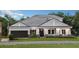A charming one-story house with gray siding and a dark brown garage door at 1400 Arklow Cir, Ormond Beach, FL 32174