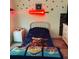 Bright bedroom with a twin-size bed, lightsaber wall decor, and Star Wars bedding at 19 Pine Court Loop, Ocala, FL 34472