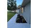 Side yard with well-maintained landscaping, featuring various plants and solar-powered path lights at 19 Pine Court Loop, Ocala, FL 34472