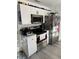 Modern kitchen featuring white cabinets, stainless steel appliances, and hexagon backsplash at 19 Pine Court Loop, Ocala, FL 34472