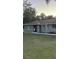 Single-story home with a gray exterior, landscaped yard, and festive holiday lights at 19 Pine Court Loop, Ocala, FL 34472