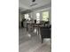 Kitchen and dining area with grey wood flooring, and a farmhouse style dining table at 19 Pine Court Loop, Ocala, FL 34472