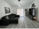Gathering room with sectional sofa, large TV, and grey wood-look flooring at 19 Pine Court Loop, Ocala, FL 34472
