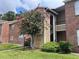 Condo building with landscaping and walkway at 5635 Devonbriar Way # 103, Orlando, FL 32822