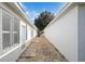 Side yard with gravel pathway and small patio area at 9076 Sw 95Th Ave # 9076, Ocala, FL 34481