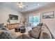 Spacious living room with comfortable seating, large TV, and sliding doors leading to the pool at 742 Orange Cosmos Blvd, Davenport, FL 33837