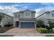 Two-story house with gray garage door and stone accents at 7405 Marker Ave, Kissimmee, FL 34747