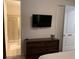 Bedroom with ensuite bathroom, dresser, and mounted TV at 7405 Marker Ave, Kissimmee, FL 34747