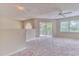 Upstairs bedroom with carpeted floor, ceiling fan, and access to a balcony at 28 Golf Villa Dr, Port Orange, FL 32128