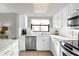 White kitchen with stainless steel appliances and granite countertops at 4445 S Atlantic Ave # 606, Ponce Inlet, FL 32127