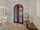 Elegant entryway with arched double doors and wood bench at 11617 Waterstone Loop Dr, Windermere, FL 34786